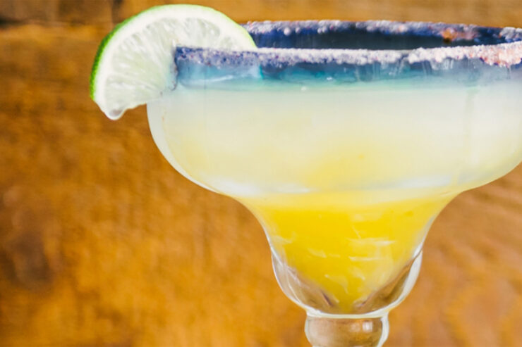 Mango margarita in a glass decorated with lime