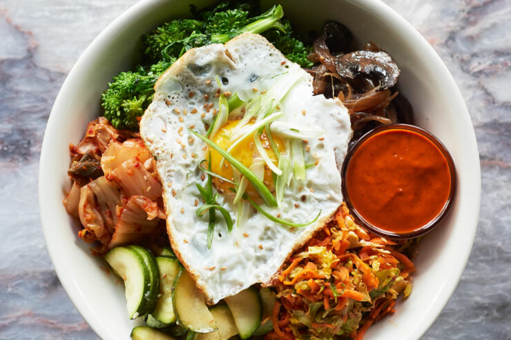 Korean Bibimap - sauteed mushrooms, greens, and zucchini, cabbage and carrot slaw, kimchi, brown rice, fried egg and gochujang sauce