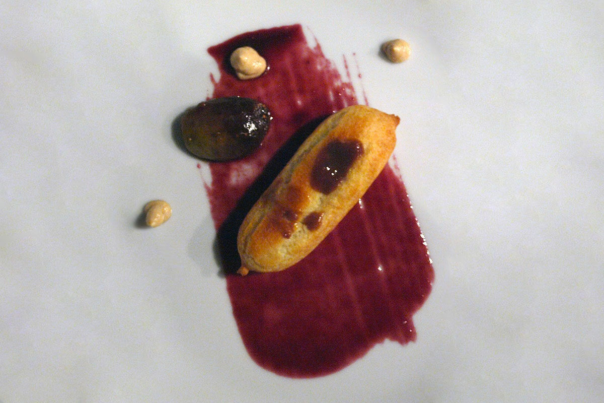 a close up of Trattoria San Giorgio's Grape Gastrique recipe, smudged on a plate