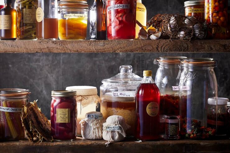 wooden shelves filled with jars of fruit and vinegar