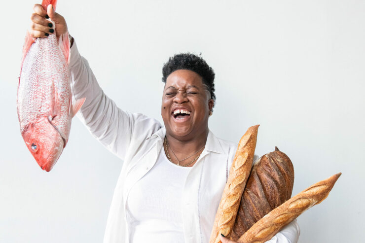 mavis-jay sanders holds a fish and bread against a white background