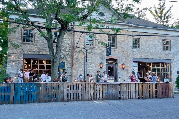people in a parklet outside a historic stone building in Kingston