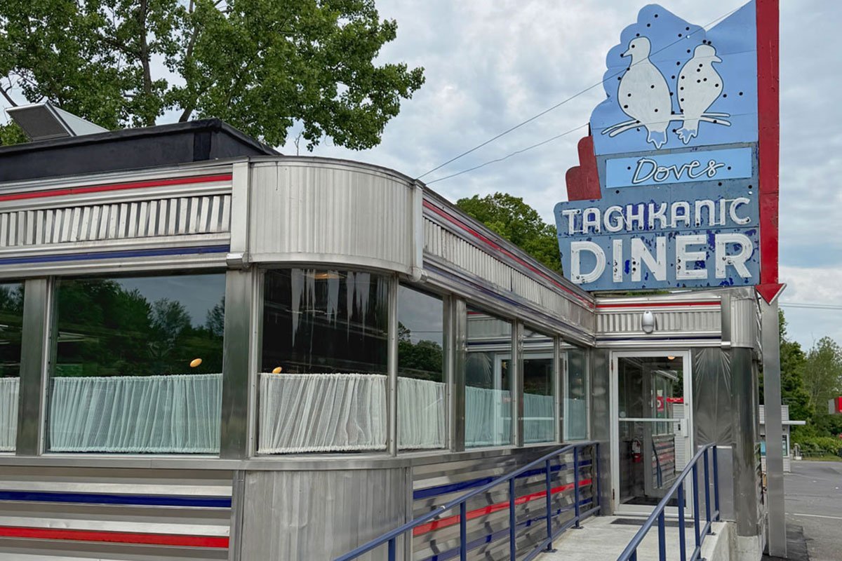 Exterior of Dove's Taghkanic Diner, a classic stainless steel roadside diner with vintage neon signage featuring two doves.